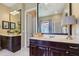 This primary bathroom offers two vanities, a large mirror, and access to a shower at 4001 Corrine Dr, Orlando, FL 32814