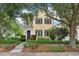 Charming two-story home featuring a balcony, black shutters, lush landscaping, and mature trees in a desirable neighborhood at 4001 Corrine Dr, Orlando, FL 32814