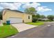 Exterior view of the home's garage, ample driveway and tidy landscaping at 4001 Corrine Dr, Orlando, FL 32814