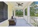 Inviting covered porch with ceiling fan, offering a relaxing outdoor seating area and view of lush greenery at 4001 Corrine Dr, Orlando, FL 32814