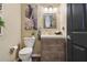 This powder room shows a wooden vanity, wall decor, and modern toilet at 4001 Corrine Dr, Orlando, FL 32814