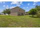 Expansive backyard featuring green grass and mature trees, offering ample space for outdoor activities and relaxation at 401 Magpie Ct, Kissimmee, FL 34759