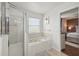 Bright bathroom featuring a glass shower with a jetted soaking tub and a neutral color scheme at 401 Magpie Ct, Kissimmee, FL 34759