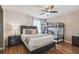 Comfortable bedroom featuring a queen-size bed and bunk beds with a ceiling fan and wood-look laminate flooring at 401 Magpie Ct, Kissimmee, FL 34759