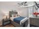 Stylized bedroom features a queen bed with decorative pillows, rustic wood furnishings, and a ceiling fan at 401 Magpie Ct, Kissimmee, FL 34759