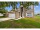 Charming two-story home with a lush green lawn and an attached two-car garage at 401 Magpie Ct, Kissimmee, FL 34759