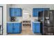 Stylish kitchen featuring blue cabinets, white countertops, and stainless steel refrigerator at 401 Magpie Ct, Kissimmee, FL 34759