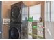 Convenient laundry room with a stacked washer and dryer and storage shelves at 401 Magpie Ct, Kissimmee, FL 34759