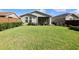 Expansive backyard with lush green grass, a well-maintained lawn, and a screened-in porch for outdoor enjoyment at 406 Alcove Dr, Groveland, FL 34736