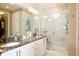 Modern bathroom with dual sinks, granite countertops, a glass-enclosed shower, and marble-style tile at 406 Alcove Dr, Groveland, FL 34736