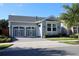 Charming single-story home featuring a two-car garage, well-manicured lawn, and beautiful exterior paint at 406 Alcove Dr, Groveland, FL 34736