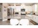 Bright kitchen featuring stainless steel appliances, white cabinets, a granite island, and modern pendant lighting at 406 Alcove Dr, Groveland, FL 34736