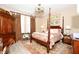 Elegant bedroom with a four-poster bed, decorative curtains, and coordinated furnishings for a relaxing retreat at 406 Alcove Dr, Groveland, FL 34736