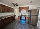 Kitchen features updated appliances, brown cabinets, granite countertops, and modern ceiling fan at 4061 Kirkland Blvd, Orlando, FL 32811