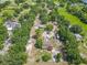 Aerial view showcases a house with solar panels and several outbuildings, surrounded by lush greenery at 4432 Freedom Rd, Kissimmee, FL 34746
