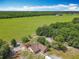 Aerial view of property showcasing landscaping, surrounding trees, and distant fields at 4432 Freedom Rd, Kissimmee, FL 34746