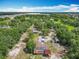 Expansive aerial view of a tree-lined property with various structures and solar panels on the house at 4432 Freedom Rd, Kissimmee, FL 34746