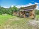 Backyard of a home featuring a shed, wooden patio, and lots of green grass at 4432 Freedom Rd, Kissimmee, FL 34746