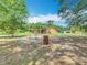 Shot of the backyard featuring a wooden patio, lush grass, and tree line at 4432 Freedom Rd, Kissimmee, FL 34746