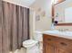 Traditional bathroom featuring dark wood vanity, toilet, and shower with curtain at 4432 Freedom Rd, Kissimmee, FL 34746