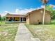 Charming single-story home with a cozy porch and a well-maintained lawn under a sunny blue sky at 4432 Freedom Rd, Kissimmee, FL 34746