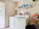 Spacious laundry room with washer, dryer, storage shelf, and bright light at 4432 Freedom Rd, Kissimmee, FL 34746