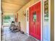 Inviting front porch featuring rocking chairs and a bright red front door with unique decor at 4432 Freedom Rd, Kissimmee, FL 34746