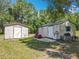 Two white sheds are on the lawn, one in the back with a door, and the other has a closed door at 4432 Freedom Rd, Kissimmee, FL 34746