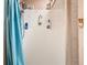 Close up shot of walk-in shower with blue curtain, shower head, and shower caddy at 4432 Freedom Rd, Kissimmee, FL 34746