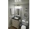 Bathroom featuring a vanity with a black marble countertop, framed mirror, and modern lighting at 4453 S Atlantic Ave # 602, Ponce Inlet, FL 32127