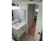 Modern bathroom featuring a white vanity with a sink and cabinet with access to the bedroom and closet at 4453 S Atlantic Ave # 602, Ponce Inlet, FL 32127