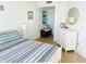 Comfortable bedroom featuring a bed with striped bedding, decor, and an entryway with a dresser and other furniture at 4453 S Atlantic Ave # 602, Ponce Inlet, FL 32127