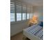 Bright bedroom boasts plantation shutters and a comfortable bed with blue and white striped linens at 4453 S Atlantic Ave # 602, Ponce Inlet, FL 32127