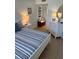 Bright bedroom features white furniture, including a dresser, lamps, and blue-striped bedding at 4453 S Atlantic Ave # 602, Ponce Inlet, FL 32127