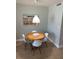 Cozy dining area features a round table with white chairs and a charming beach-themed art piece at 4453 S Atlantic Ave # 602, Ponce Inlet, FL 32127