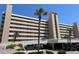 Beachside condo building featuring a parking garage, palm trees, and multiple balconies at 4453 S Atlantic Ave # 602, Ponce Inlet, FL 32127