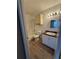 Bathroom featuring wood-look flooring, vanity, mirror, light fixture, toilet, and shower/tub combination at 5540 Devonbriar Way # 103, Orlando, FL 32822