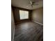 Bedroom featuring wood-look floors, a ceiling fan, neutral paint and a large window at 5540 Devonbriar Way # 103, Orlando, FL 32822