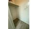A closet with wood-look floors has a utility panel on the back wall and shelving above at 5540 Devonbriar Way # 103, Orlando, FL 32822