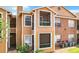 View of the exterior elevation of the building with a combination of wood and brick, and a few windows at 5540 Devonbriar Way # 103, Orlando, FL 32822