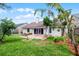 Backyard view features a brick patio, lush lawn, and mature landscaping at 635 Holbrook Cir, Lake Mary, FL 32746