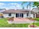 Backyard patio with sliding glass doors and privacy landscaping in a well-maintained yard at 635 Holbrook Cir, Lake Mary, FL 32746