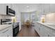 Modern kitchen with white cabinetry, stainless steel appliances, and hardwood floors at 635 Holbrook Cir, Lake Mary, FL 32746