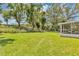 Expansive backyard featuring lush green grass, mature trees, and a secure fence for privacy at 638 Sun Bluff Ln, Apopka, FL 32712