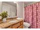 Bathroom features a granite countertop vanity, toilet, and pink polka dot shower curtain at 638 Sun Bluff Ln, Apopka, FL 32712