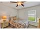 Comfortable bedroom featuring floral bedding, a ceiling fan, and a bright window view at 638 Sun Bluff Ln, Apopka, FL 32712