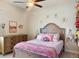 Light and airy bedroom with wooden furniture, flower accents, and rainbow-themed accessories at 6686 Treymont Dr, Lakeland, FL 33813