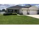 Well-maintained home with a two-car garage, green lawn, and shrubbery at 6686 Treymont Dr, Lakeland, FL 33813