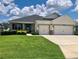 Charming single-story home with a well-manicured lawn and a three-car garage at 6686 Treymont Dr, Lakeland, FL 33813