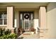 Inviting front entrance with decorative door, stone pillars, and potted plants at 6686 Treymont Dr, Lakeland, FL 33813